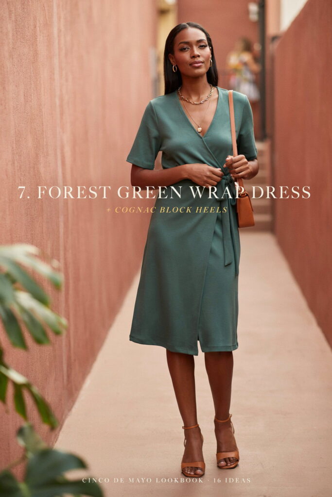Forest green wrap dress on deep brown skin styled with cognac block-heeled sandals and layered gold chain necklaces for an elegant Cinco de Mayo outfit.