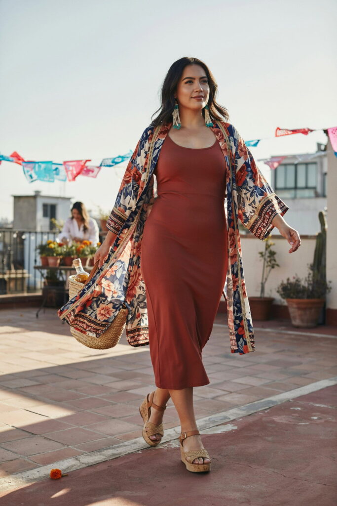 23 Plus Size Cinco de Mayo Outfit Ideas for the Cutest Fiesta Look Ever 23 Woman wearing a bold printed kimono duster over a solid fitted midi dress with platform sandals and tassel earrings, creating a stylish and effortless plus-size Cinco de Mayo outfit for day or evening celebrations.