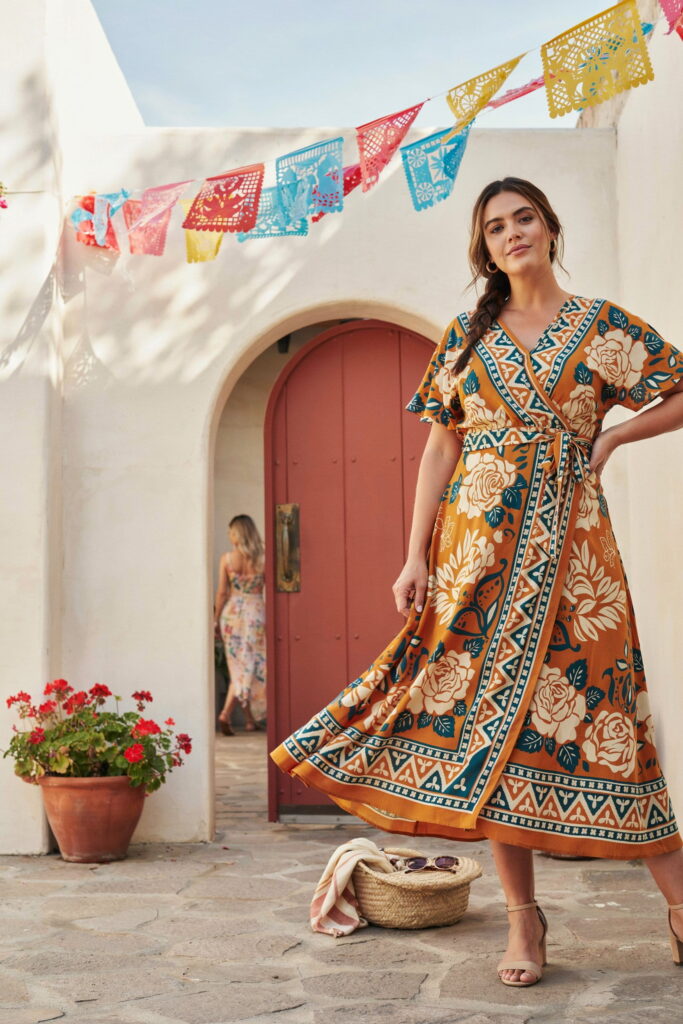 23 Plus Size Cinco de Mayo Outfit Ideas for the Cutest Fiesta Look Ever 9 Plus-size woman wearing a bold wrap maxi dress with a flattering V-neckline and flowing skirt, creating a confident, elegant, and comfortable Cinco de Mayo outfit for festive celebrations.