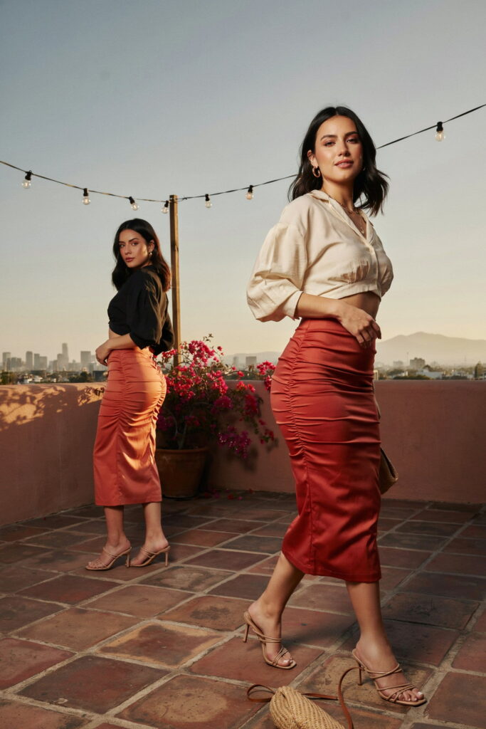 Curvy woman wearing a coral ruched bandage midi skirt with a fitted solid crop blouse and nude heeled sandals for a glamorous Cinco de Mayo outfit.