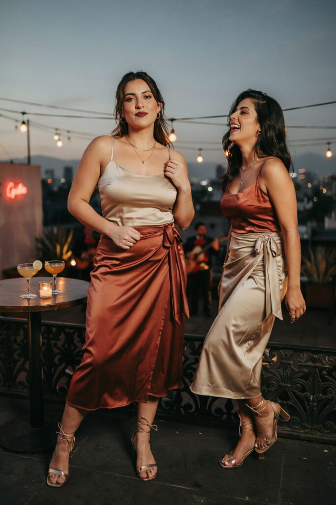 Curvy woman wearing a deep red satin wrap midi skirt with a fitted satin cami, gold strappy heels, and bold evening makeup for a chic Cinco de Mayo party outfit.