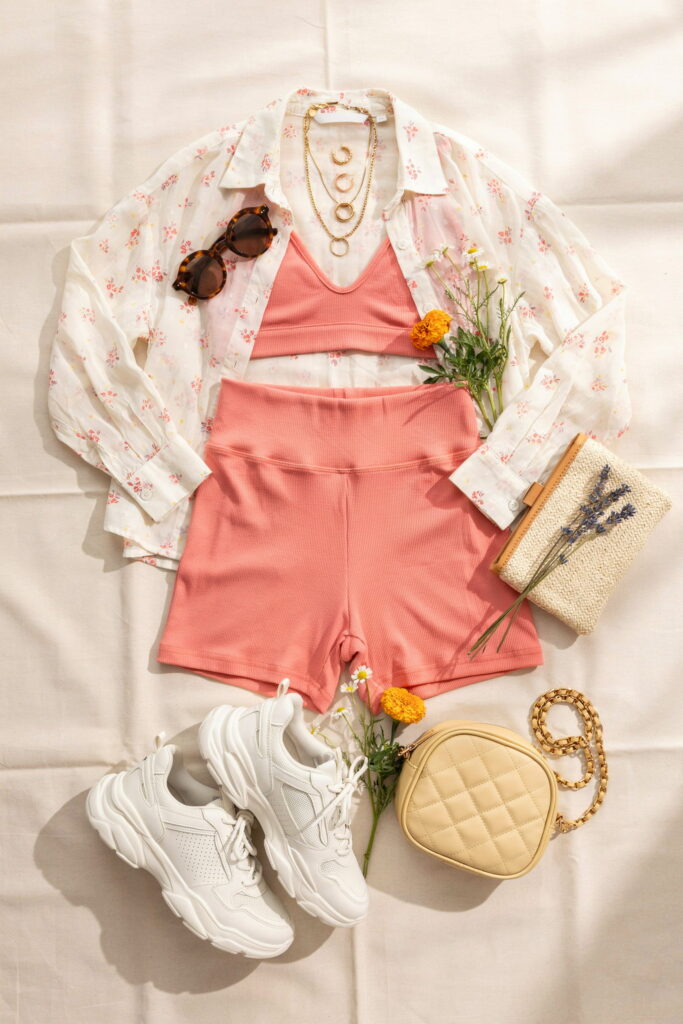 Teen wearing a sheer floral button-up top open over a bright bralette with solid biker shorts, chunky sneakers, and a mini bag for an effortless casual Cinco de Mayo outfit.