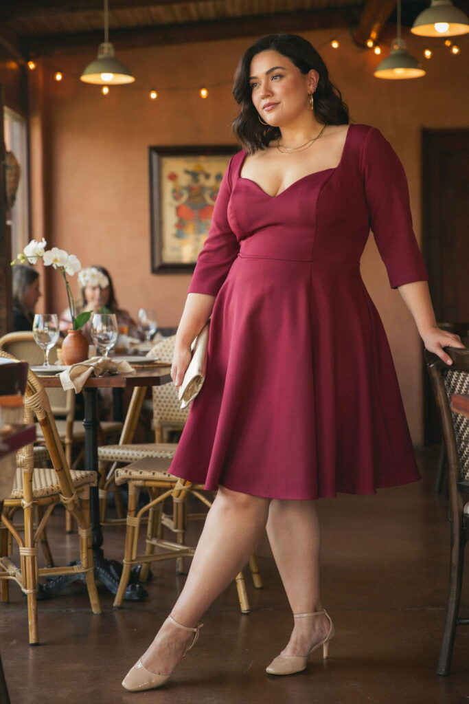 23 Plus Size Cinco de Mayo Outfit Ideas for the Cutest Fiesta Look Ever 20 Woman wearing a sweetheart fit-and-flare dress in deep magenta with kitten heels, creating an elegant and sophisticated plus-size Cinco de Mayo dinner outfit.